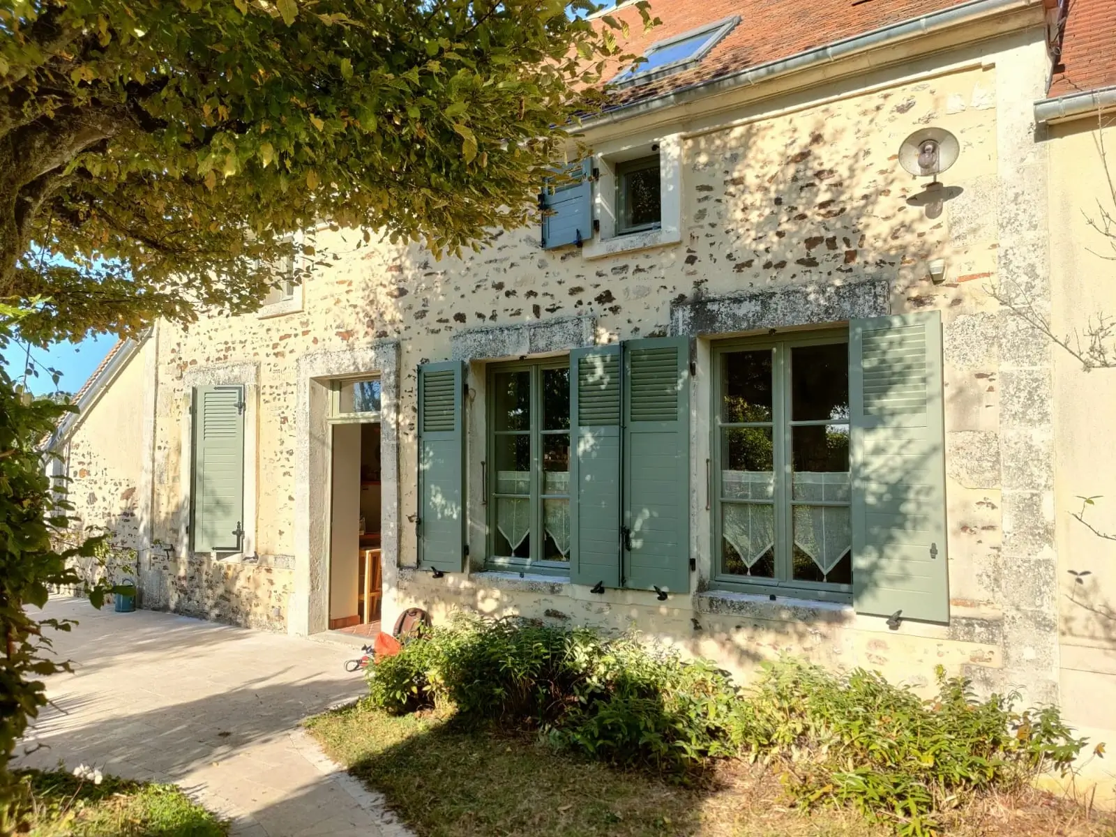Maison en pierre avec volets battants bleus